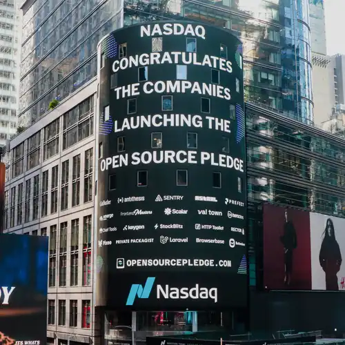 The big Nasdaq screen in Times Square bearing a message saying “Nasdaq celebrates one year of the Open Source Pledge and the companies who pay maintainers”, and many company logos underneath